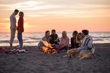 Image showing Couple enjoying with friends at sunset on the beach