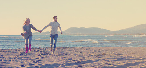 Image showing Loving young couple on a beach at autumn sunny day