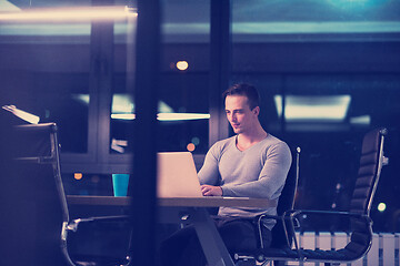 Image showing man working on laptop in dark office