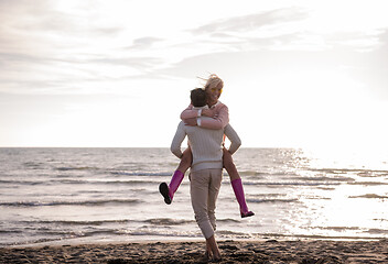 Image showing Loving young couple on a beach at autumn sunny day