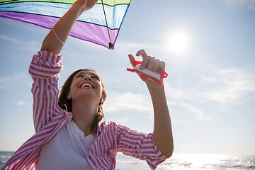 Image showing Young Woman with kite at beach on autumn day