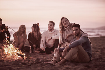 Image showing Group Of Young Friends Sitting By The Fire at beach