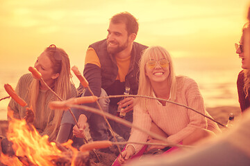 Image showing Group Of Young Friends Sitting By The Fire at beach