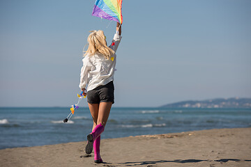 Image showing Young Woman with kite at beach on autumn day