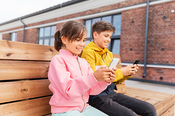 Image showing children with smartphones sitting on street bench