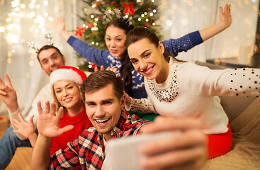 Image showing friends celebrating christmas and taking selfie