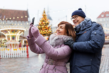 Image showing senior couple taking selfie at christmas market