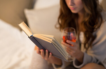 Image showing close up of woman reading book and drinking wine