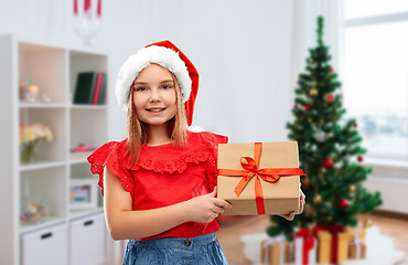 Image showing girl in santa hat with christmas gift at home