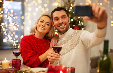 Image showing happy couple taking selfie at christmas dinner