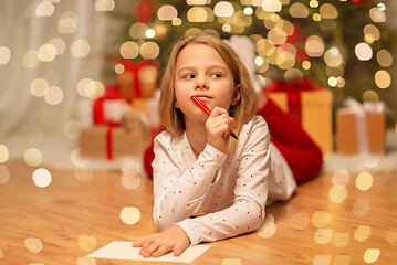 Image showing girl writing christmas wish list at home