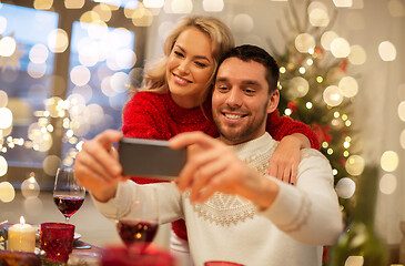 Image showing happy couple taking selfie at christmas dinner