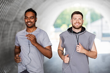 Image showing male friends with earphones running outdoors