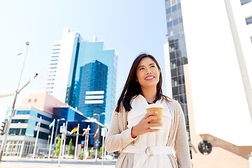 Image showing smiling woman with takeaway coffee cup in city