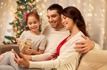 Image showing family with smartphone at home on christmas