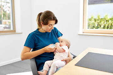 Image showing mother feeding baby daughter with milk formula