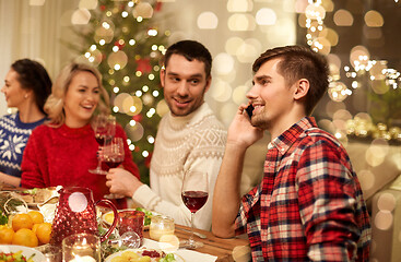 Image showing man calling on smartphone at christmas dinner