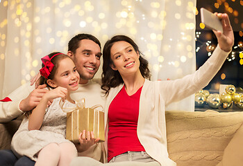 Image showing happy family with christmas present at home