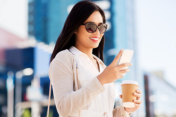 Image showing smiling woman with smartphone and coffee in city