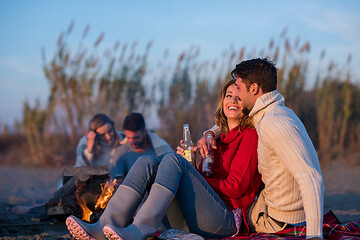 Image showing Couple enjoying with friends at sunset on the beach