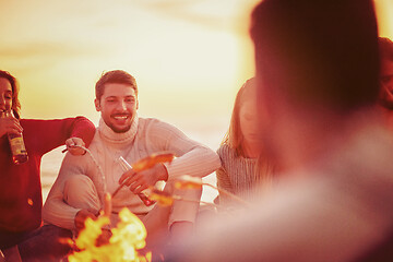 Image showing Group Of Young Friends Sitting By The Fire at beach