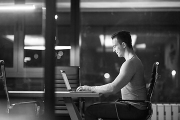 Image showing man working on laptop in dark office