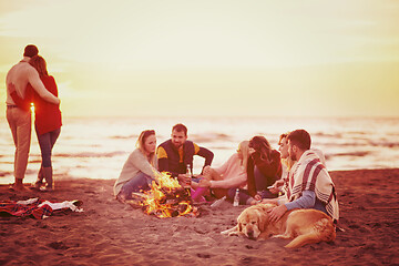 Image showing Couple enjoying with friends at sunset on the beach