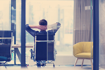 Image showing young businessman relaxing at the desk