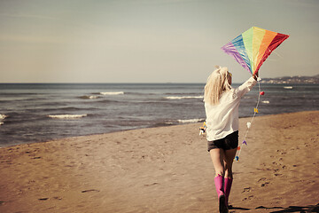 Image showing Young Woman with kite at beach on autumn day