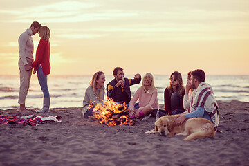 Image showing Couple enjoying with friends at sunset on the beach