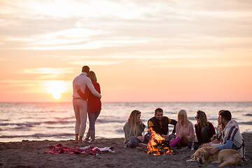 Image showing Couple enjoying with friends at sunset on the beach