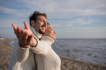 Image showing Loving young couple on a beach at autumn sunny day