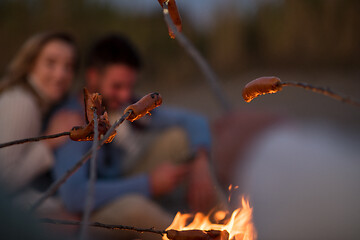 Image showing Group Of Young Friends Sitting By The Fire at beach