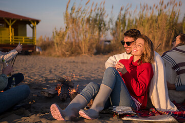 Image showing Couple enjoying with friends at sunset on the beach