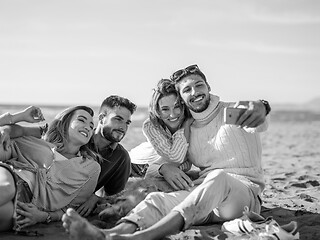 Image showing Group of friends having fun on beach during autumn day