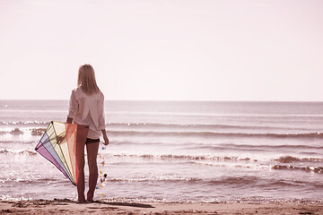 Image showing Young Woman with kite at beach on autumn day