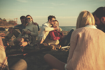 Image showing Couple enjoying with friends at sunset on the beach