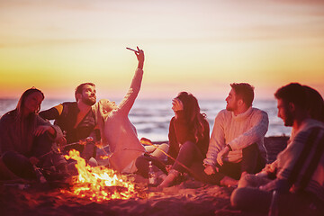 Image showing a group of friends enjoying bonfire on beach