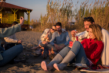 Image showing Couple enjoying with friends at sunset on the beach