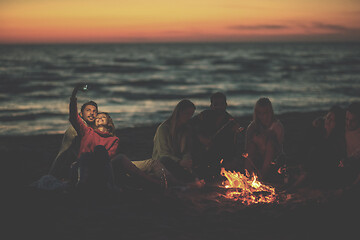 Image showing a group of friends enjoying bonfire on beach