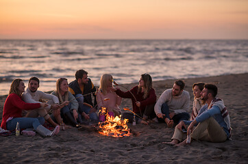 Image showing Group Of Young Friends Sitting By The Fire at beach