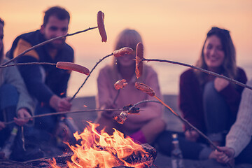 Image showing Group Of Young Friends Sitting By The Fire at beach