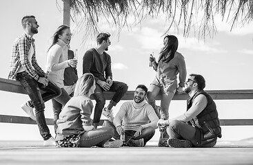 Image showing Group of friends having fun on autumn day at beach