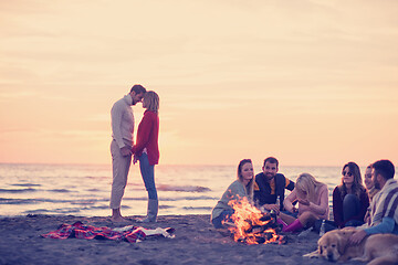 Image showing Couple enjoying with friends at sunset on the beach