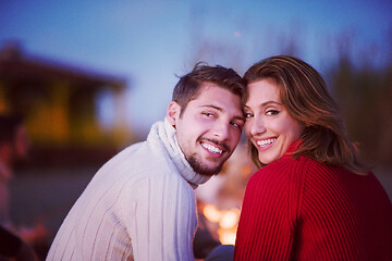 Image showing Couple enjoying with friends at sunset on the beach