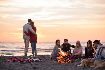 Image showing Couple enjoying with friends at sunset on the beach