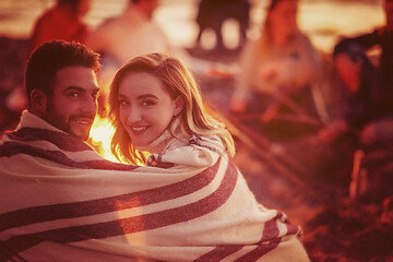 Image showing Couple enjoying with friends at sunset on the beach