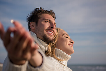 Image showing Loving young couple on a beach at autumn sunny day