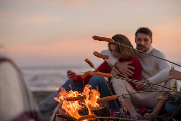 Image showing Group Of Young Friends Sitting By The Fire at beach