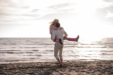 Image showing Loving young couple on a beach at autumn sunny day